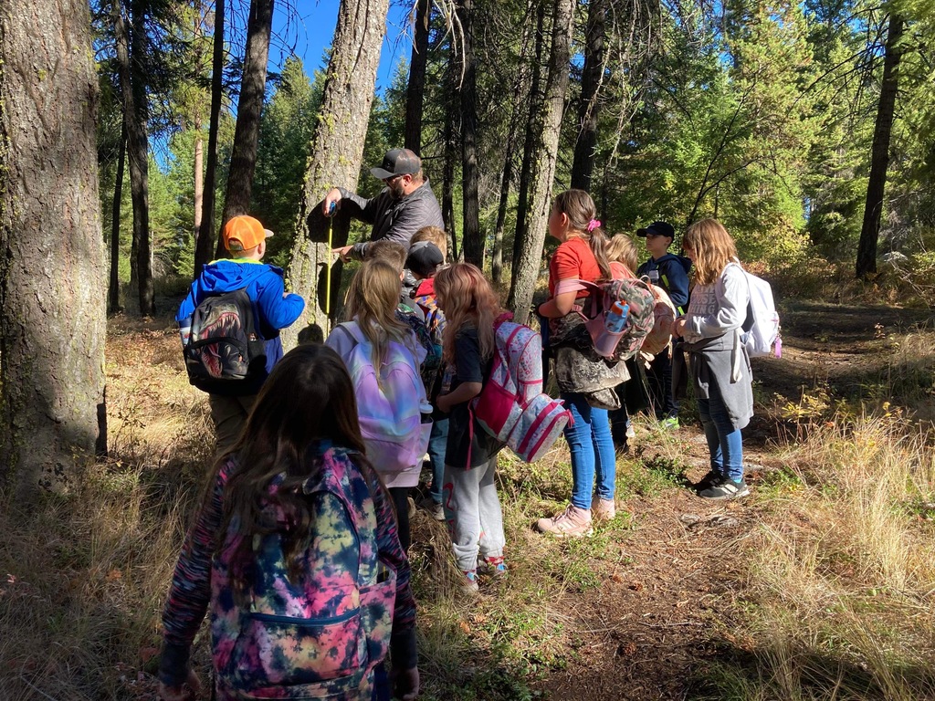 Seth Krohn of the Curlew Job Corp  showing students how to measure the diameter of a Douglas Fir
